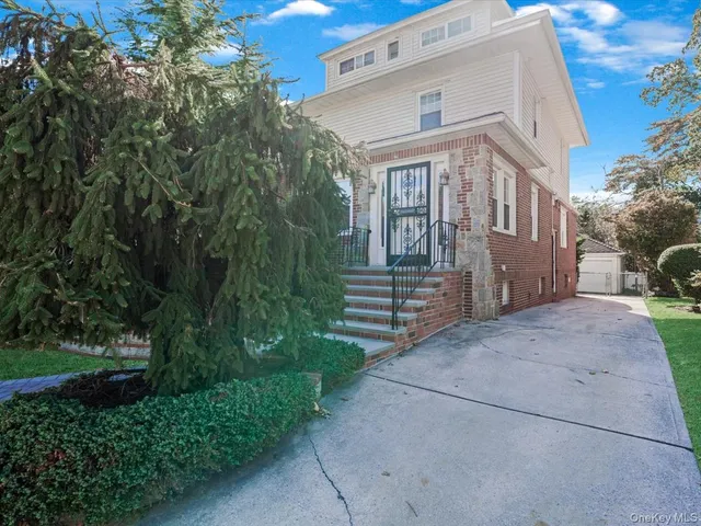 a front view of a house with a yard and outdoor seating