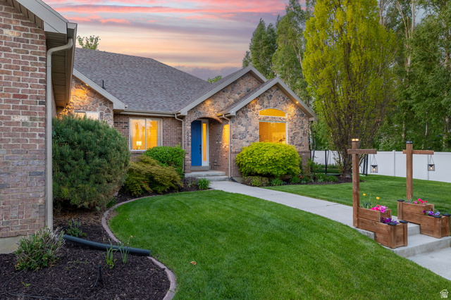 6208 West Bull River Road Highland, UT 84003 - Photo 2 of 90 Stone and brick exterior featuring a prominent arched window and a blue entry door