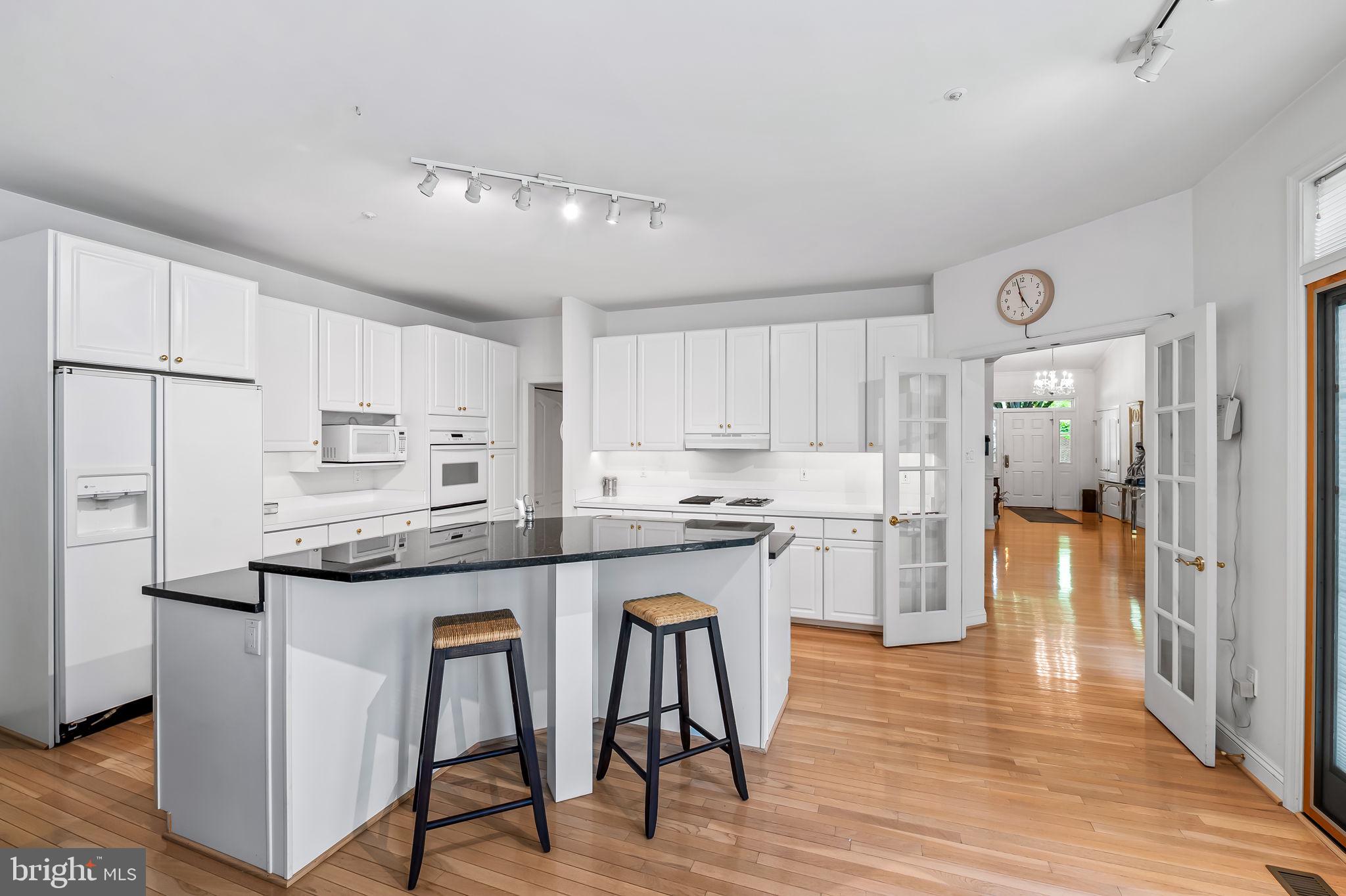 16 Roland Green, Unit 8 Baltimore, MD 21210 - Photo 14 of 55 a kitchen with stainless steel appliances granite countertop white cabinets and wooden floor