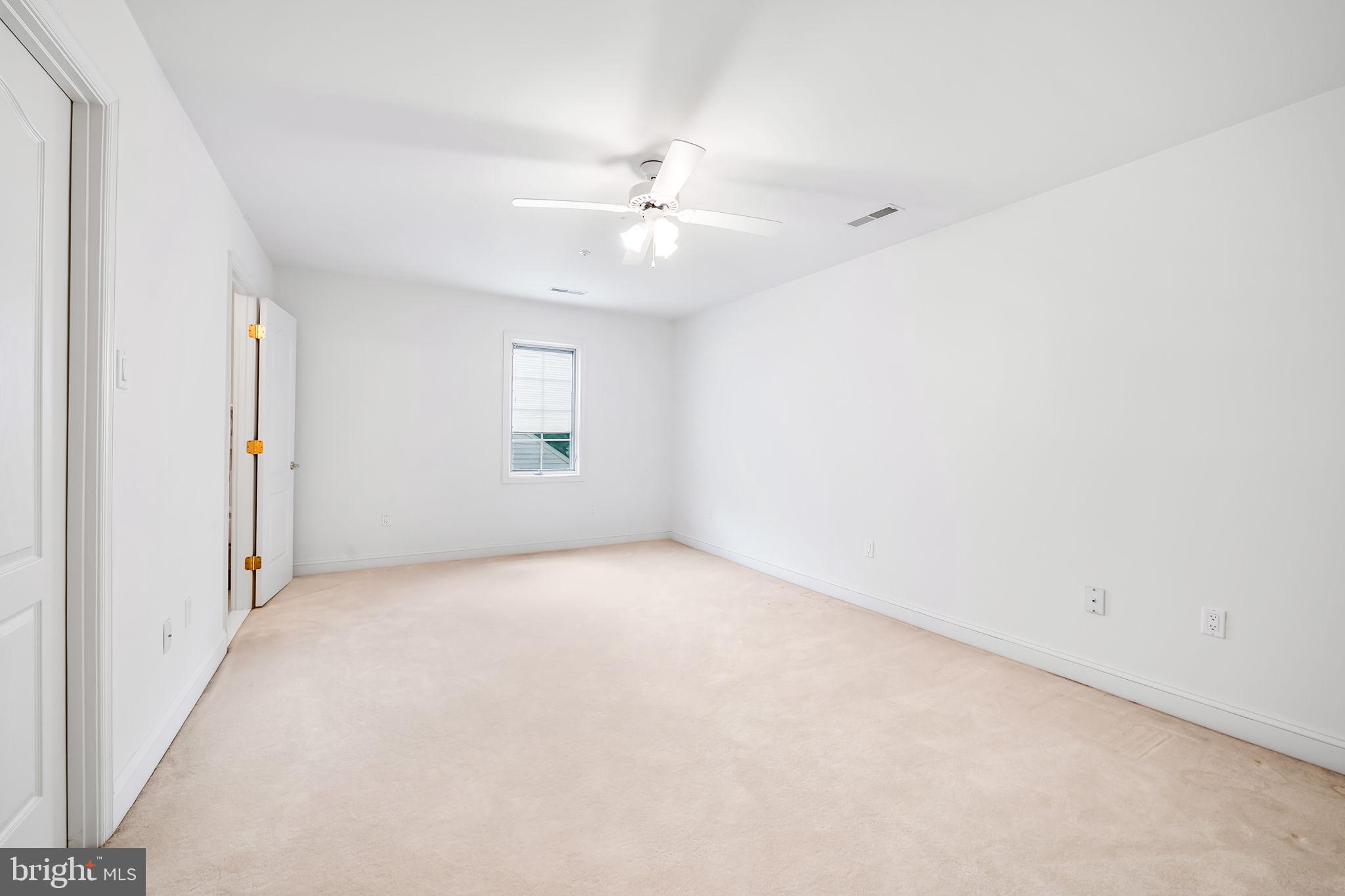 16 Roland Green, Unit 8 Baltimore, MD 21210 - Photo 39 of 55 an empty room with a ceiling fan and a window