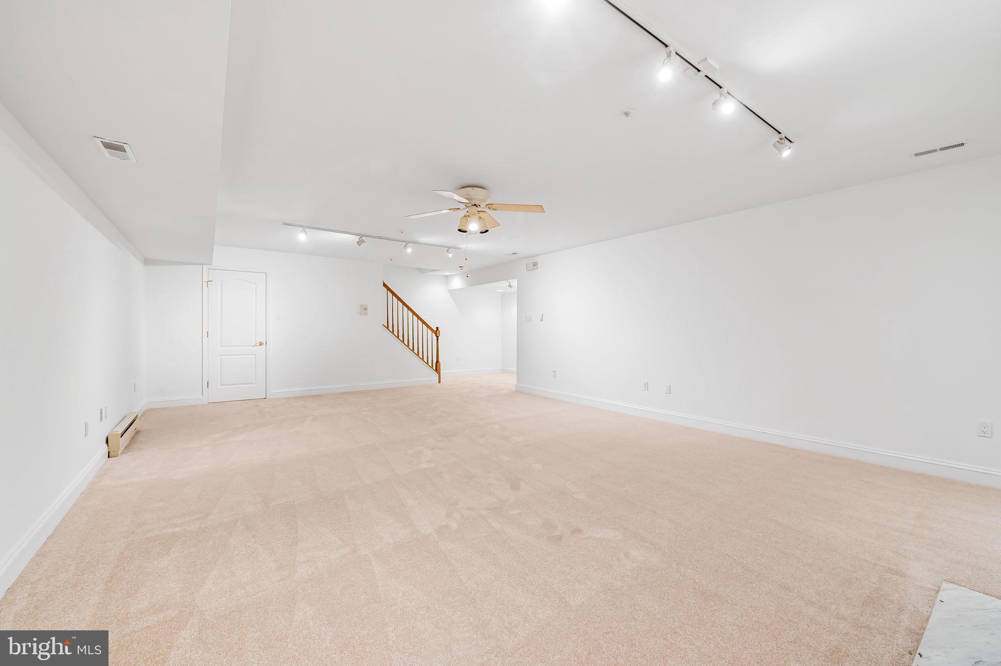 16 Roland Green, Unit 8 Baltimore, MD 21210 - Photo 44 of 55 an empty room with a chandelier fan and windows