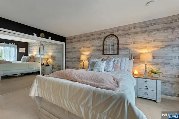 a bedroom with a bed and a dresser next to a window