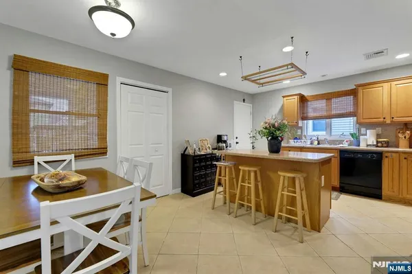 a kitchen with kitchen island granite countertop wooden cabinets and a refrigerator