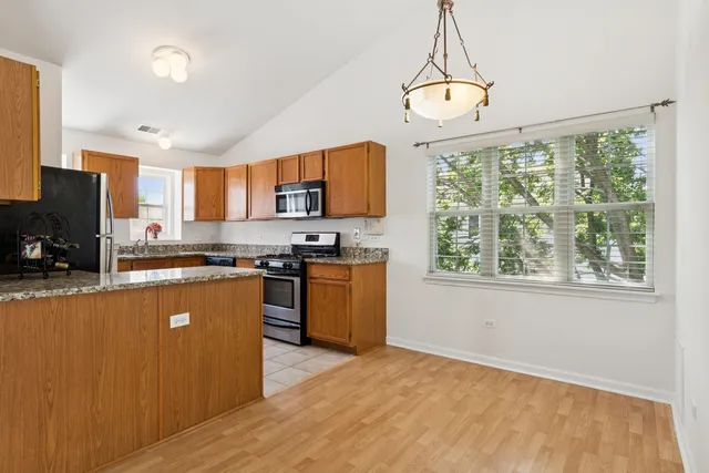 a kitchen with granite countertop a stove a sink a center island and a window