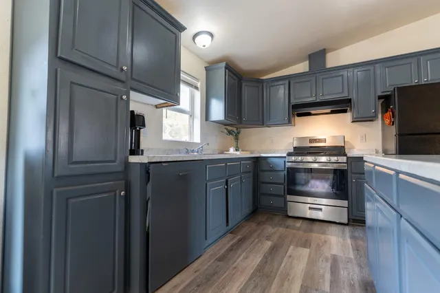 a kitchen with granite countertop a refrigerator stove and microwave