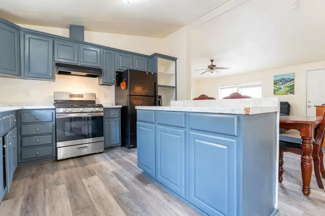 a kitchen with stainless steel appliances kitchen island wooden cabinets and granite counter tops