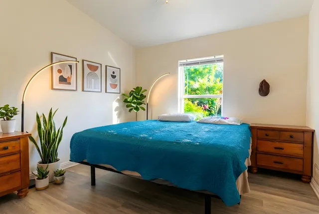 a bedroom with bed and wooden floor