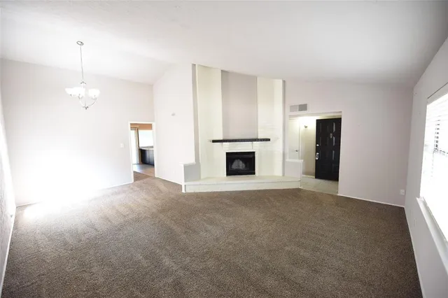 a view of an empty room with window and fire place