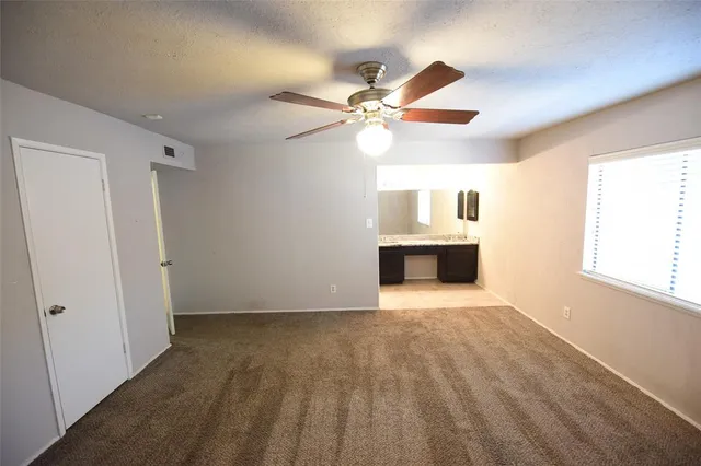 an empty room with windows and fireplace