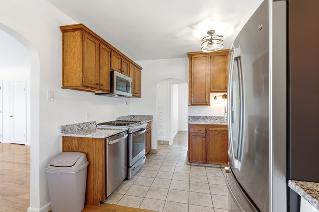 1925 South Main Street Bountiful, UT 84010 - Photo 14 of 48 Kitchen featuring wood cabinetry, stainless steel appliances, speckled stone countertops, and tile flooring