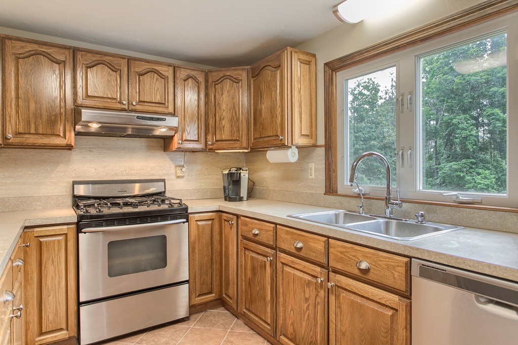 10 Farley Brook Road Chelmsford, MA 01824 - Photo 7 of 30 a kitchen with granite countertop white cabinets a sink and a stove