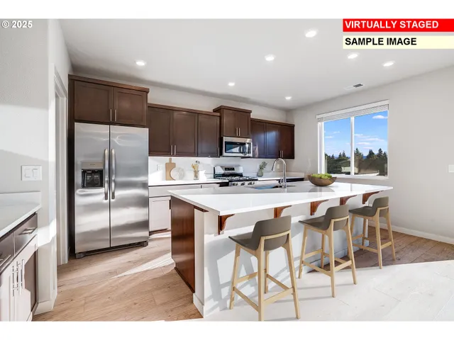 a kitchen with kitchen island granite countertop a refrigerator and a stove top oven
