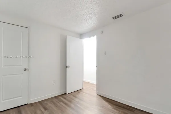 a view of an empty room and wooden floor