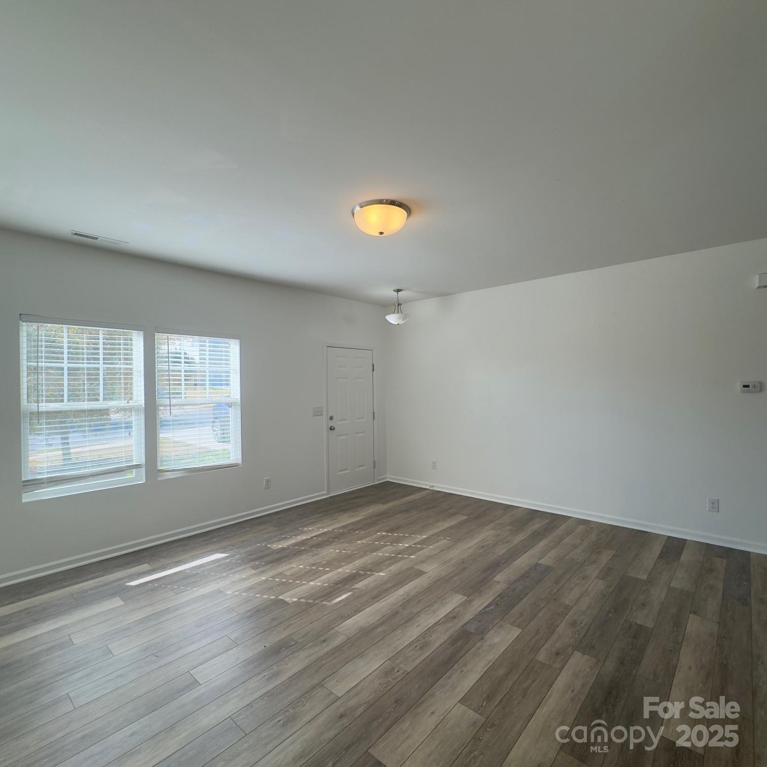 105 Abel Peterson Drive Mount Holly, NC 28120 - Photo 32 of 36 an empty room with wooden floor and windows