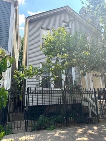 a view of a brick house with a large window and potted plants