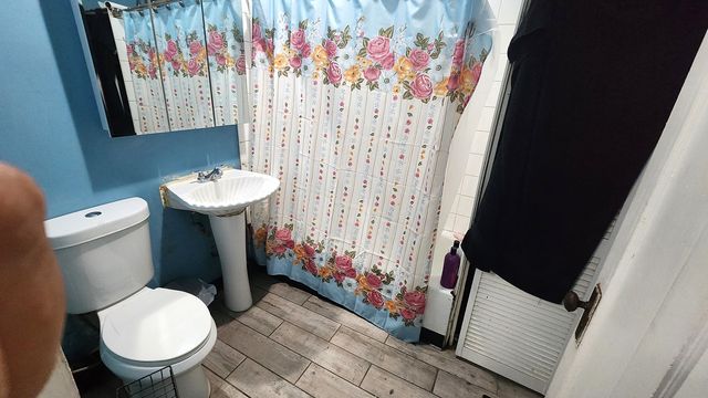 a bathroom with a toilet and a shower curtain