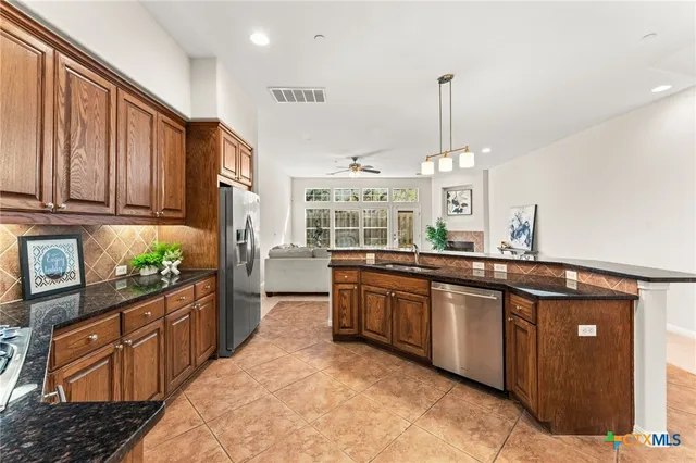 a kitchen with stainless steel appliances granite countertop a stove top oven a sink and dishwasher a oven with granite countertops