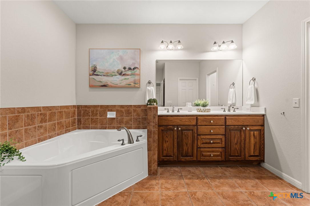 10300 Morado Cove, Unit 503 Austin, TX 78759 - Photo 6 of 33 The primary bathroom has a large tub, double vanities, and large walk-in shower.