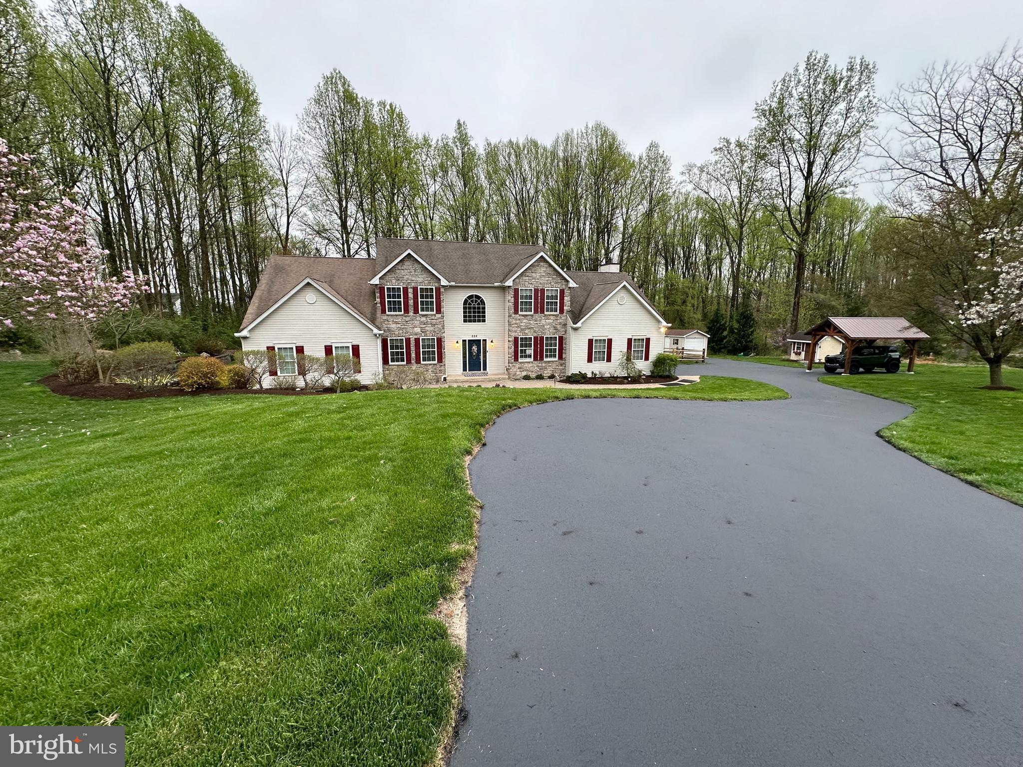 a front view of a house with a yard and trees