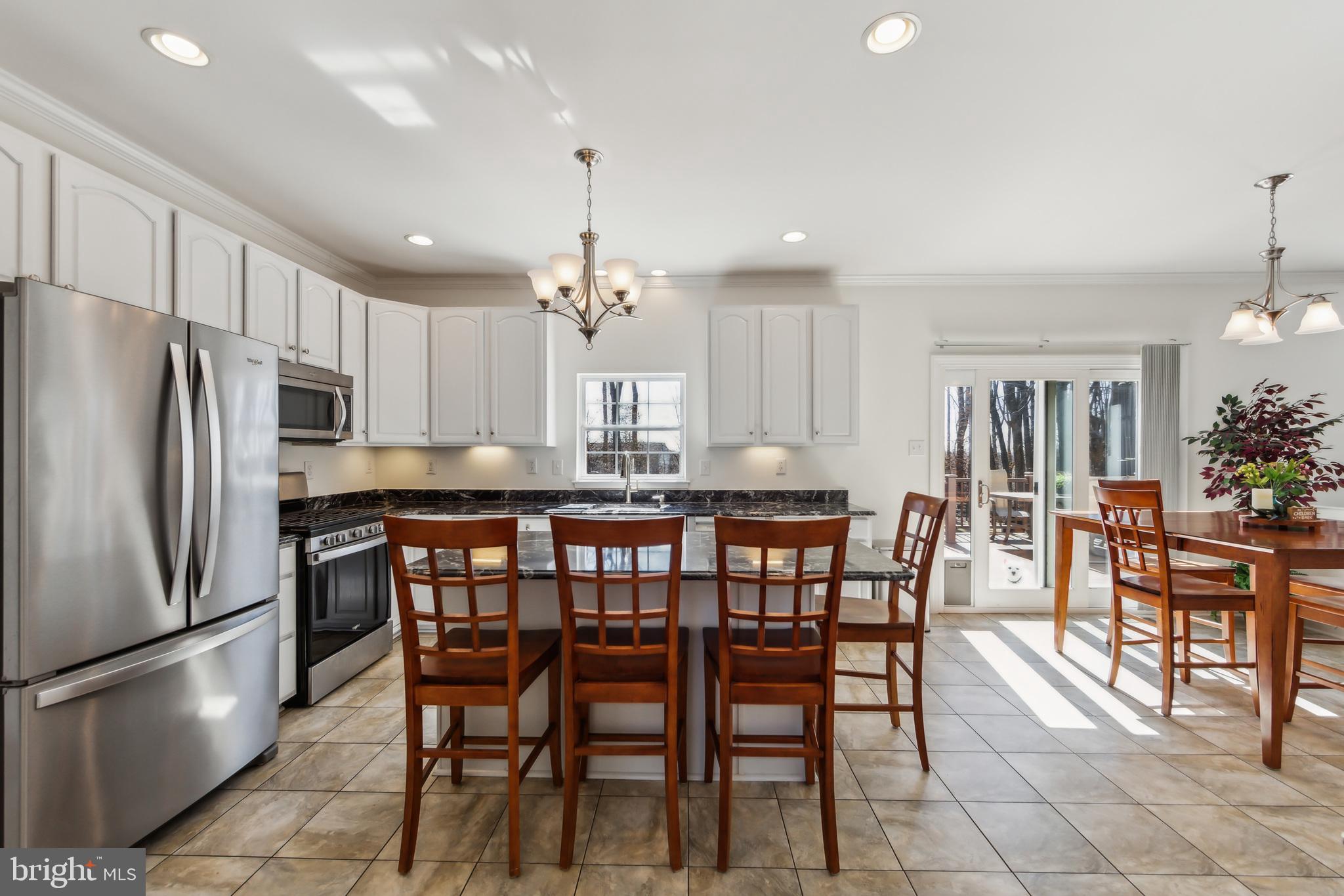684 Highspire Road Glenmoore, PA 19343 - Photo 12 of 46 a kitchen with stainless steel appliances granite countertop a dining table chairs refrigerator and cabinets