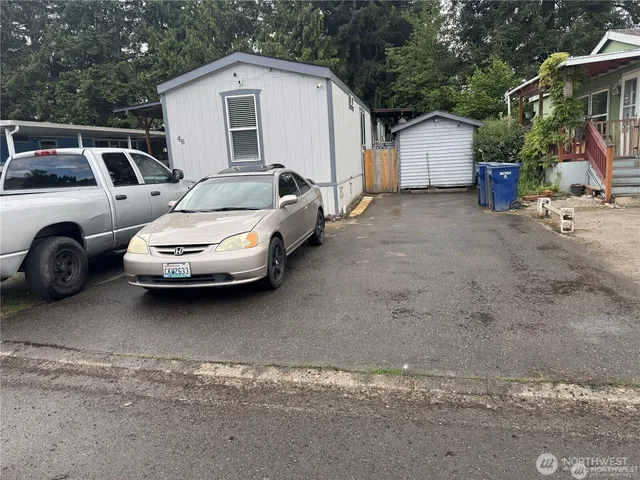 a white car parked in front of white house