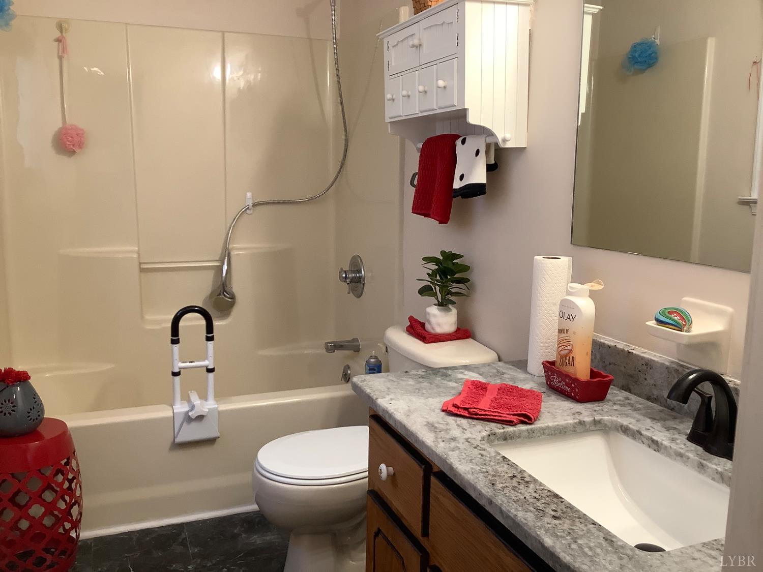 1564 Calohan Road Rustburg, VA 24588 - Photo 12 of 29 a bathroom with a granite countertop sink a toilet and a shower curtain