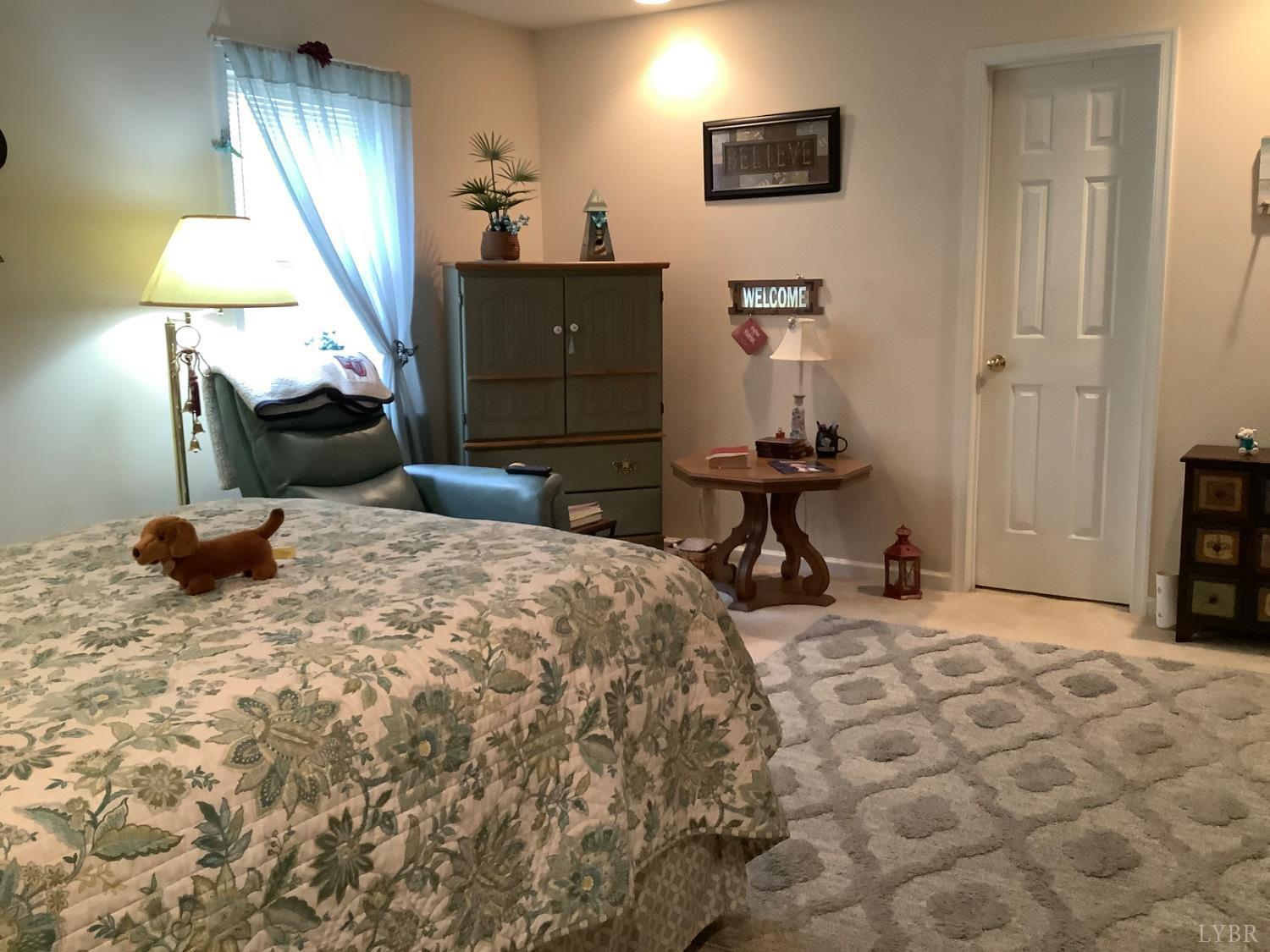 1564 Calohan Road Rustburg, VA 24588 - Photo 8 of 29 a bedroom with a bed and a chandelier