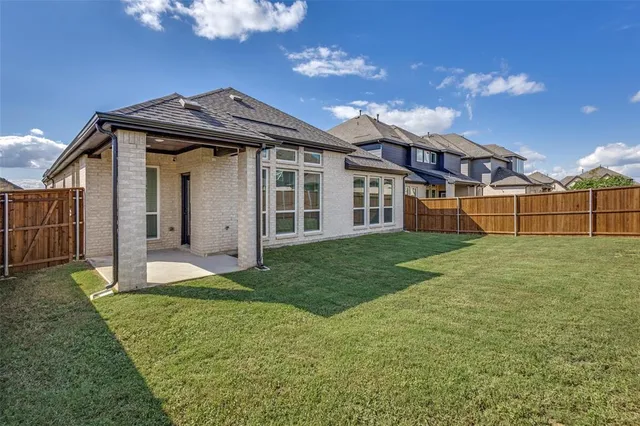 a view of a house with a small yard and wooden fence