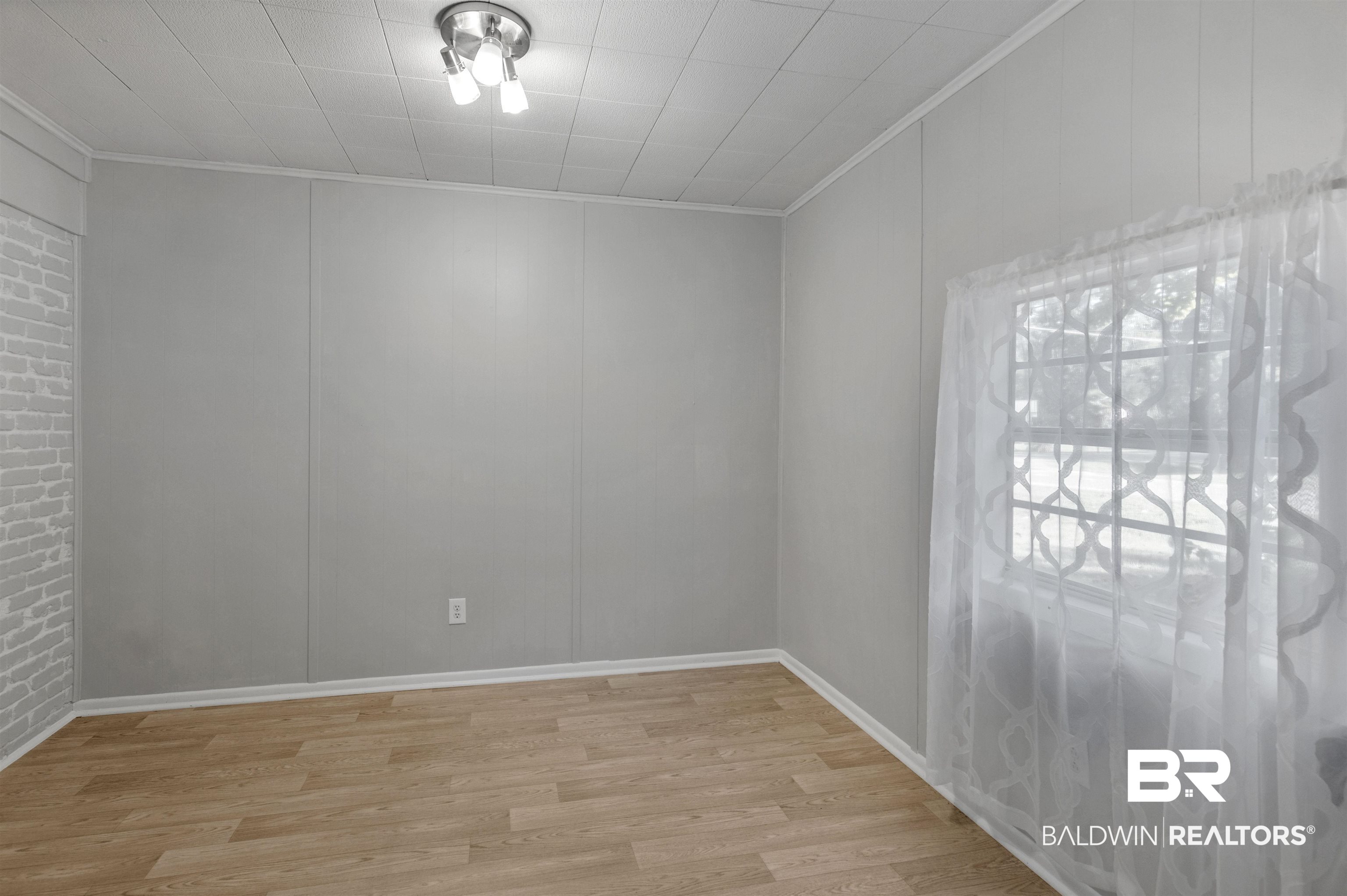 501 West Craig Street Atmore, AL 36502 - Photo 10 of 26 Empty room featuring light hardwood / wood-style flooring and ornamental molding
