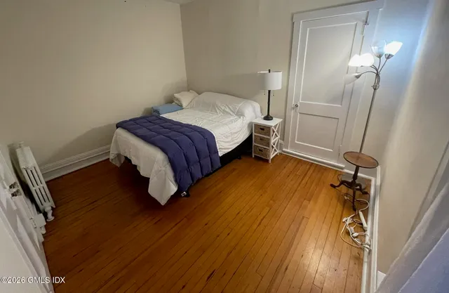a bedroom with a bed and wooden floor