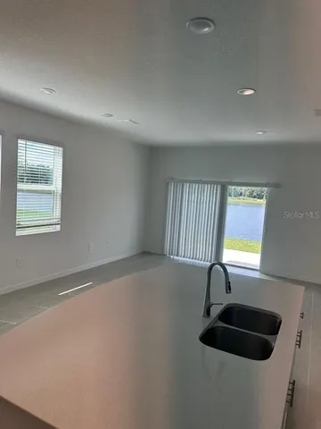 an empty room with windows and ceiling fan