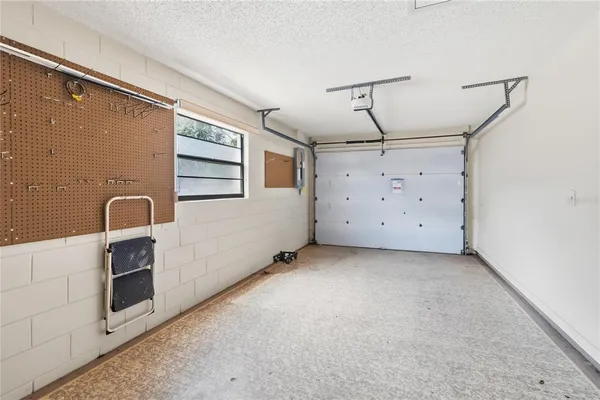 a view of a garage with stainless steel appliances wooden floor and a window