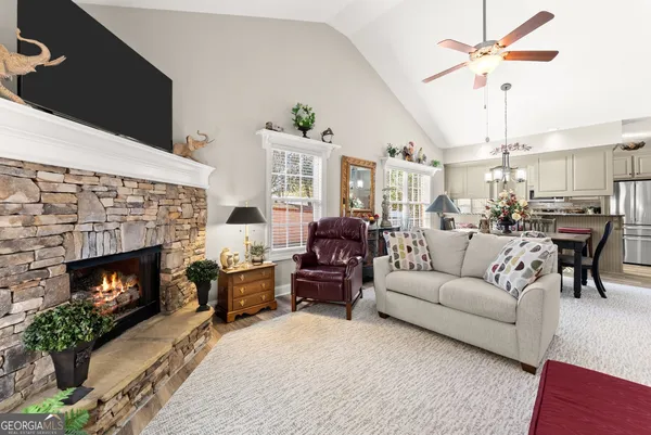 a living room with furniture a fireplace and a chandelier