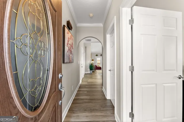 a view of a hallway with wooden floor and a door