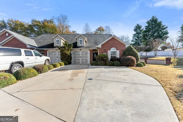 a front view of a house with a yard and potted plants