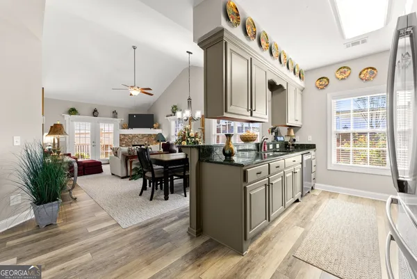 a kitchen with stainless steel appliances kitchen island granite countertop a stove a sink and a refrigerator