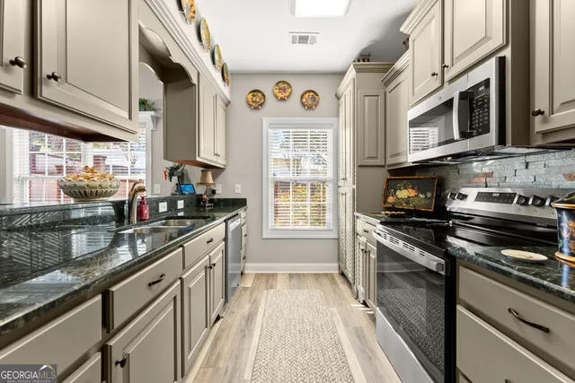a kitchen with stainless steel appliances granite countertop a stove and a sink