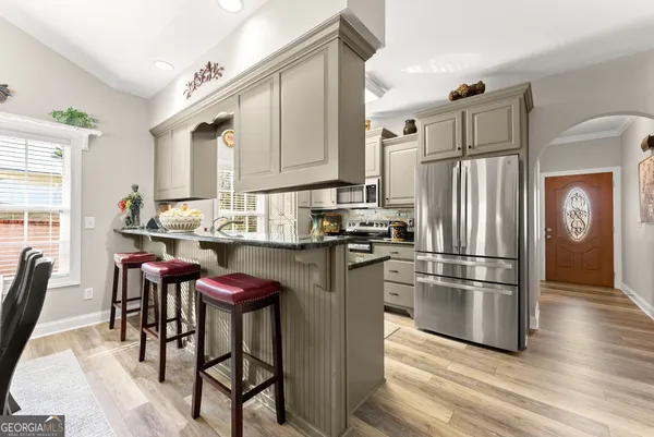 a kitchen with stainless steel appliances granite countertop a refrigerator and a stove top oven