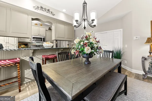 a dining room with furniture a chandelier and wooden floor
