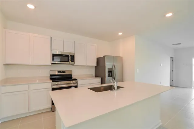 a kitchen with stainless steel appliances a refrigerator stove microwave and sink