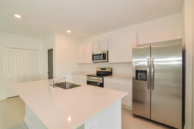 a kitchen with stainless steel appliances a refrigerator sink and stove