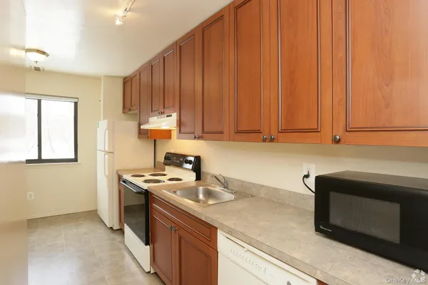 a kitchen with stainless steel appliances wooden cabinets and a stove top oven