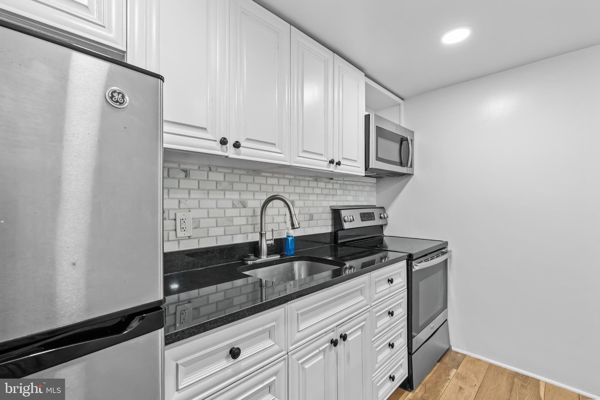 2032 15th Street Northwest, Unit 2 Washington, DC 20009 - Photo 12 of 28 a kitchen with stainless steel appliances granite countertop a sink stove and cabinets