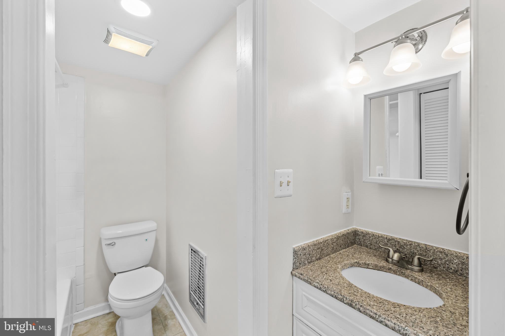 2032 15th Street Northwest, Unit 2 Washington, DC 20009 - Photo 14 of 28 a bathroom with a granite countertop sink a toilet and a mirror