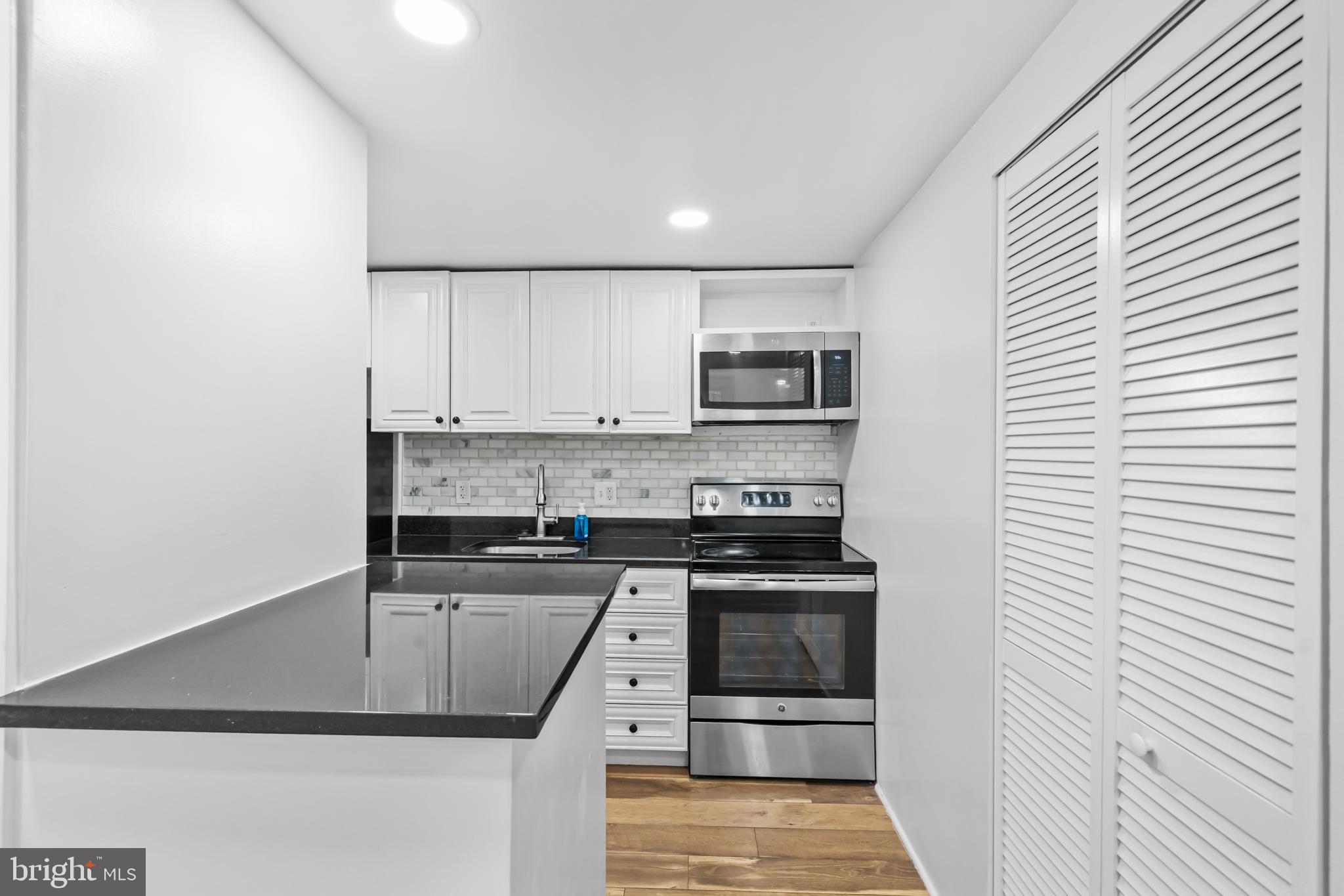 2032 15th Street Northwest, Unit 2 Washington, DC 20009 - Photo 9 of 28 a kitchen with kitchen island white cabinets and stainless steel appliances