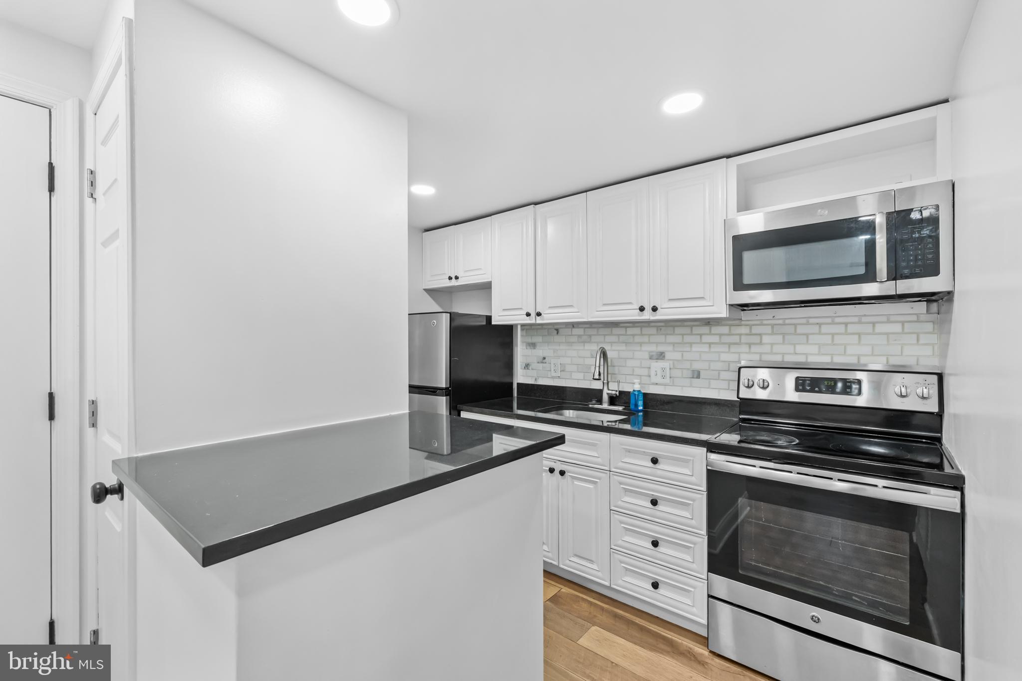 2032 15th Street Northwest, Unit 2 Washington, DC 20009 - Photo 10 of 28 a kitchen with granite countertop a stove microwave and sink