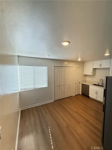 a view of a kitchen with wooden floor and electronic appliances