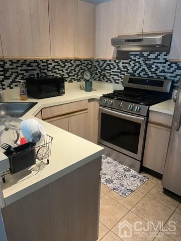 a stove top oven sitting inside of a kitchen