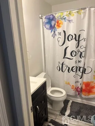 a bathroom with a toilet and a shower curtain