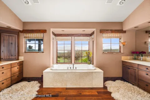 a spacious bathroom with a tub sink and a window